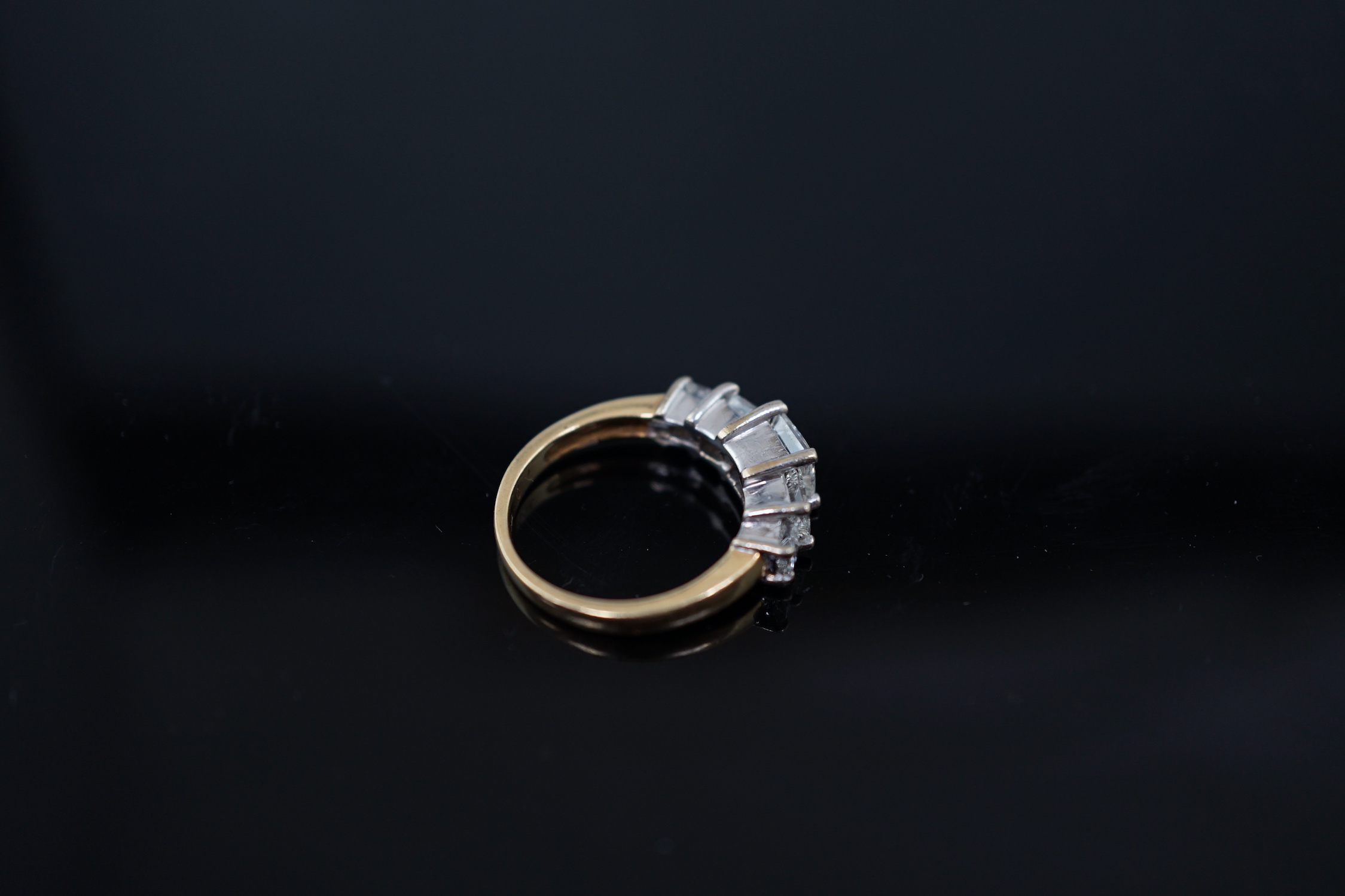 A modern 18ct gold and graduated five stone princess cut diamond set half hoop ring